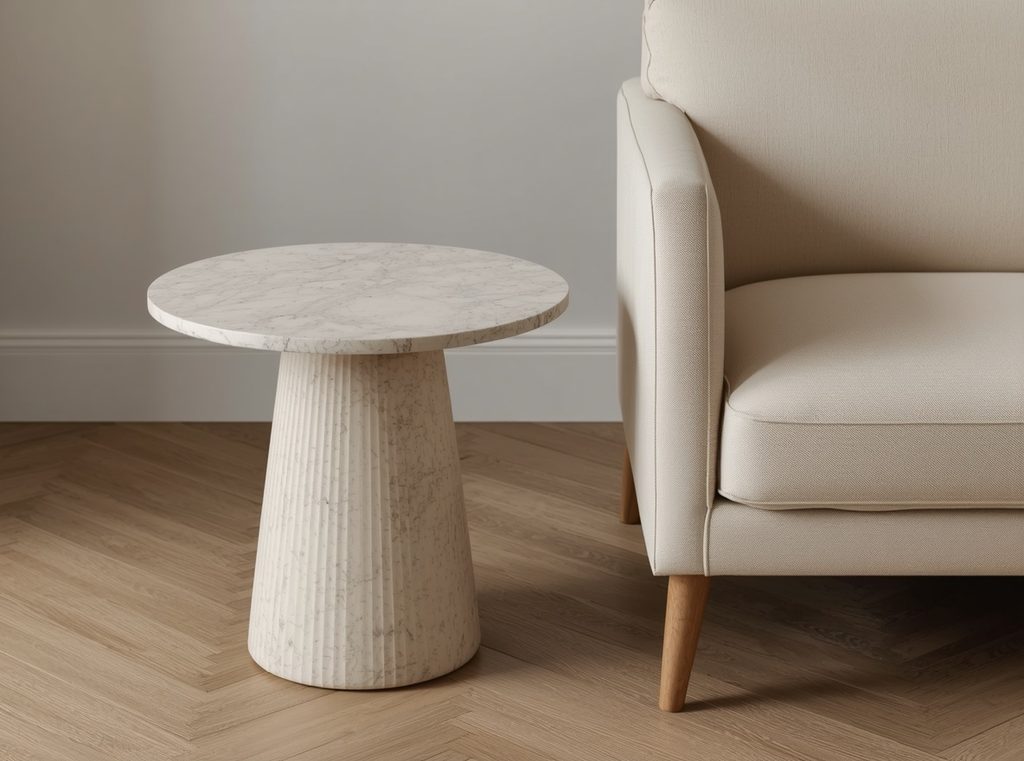 A small travertine side table beside a soft cream chair with linen upholstery and a natural wood floor